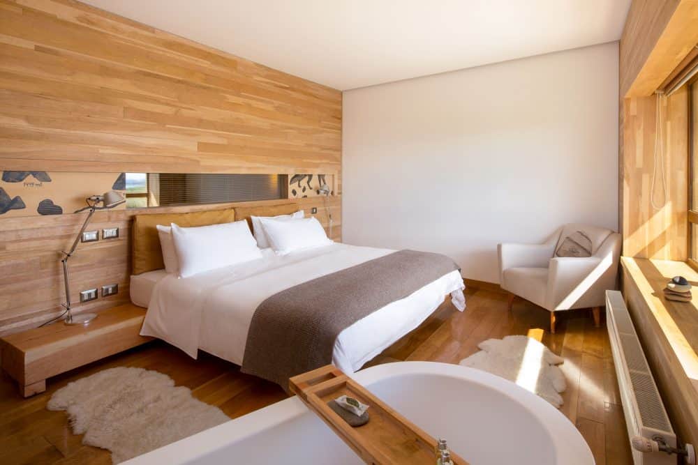 View of the interior of Tierra Patagonia's standard rooms with in room tub and view of Torres del Paine.