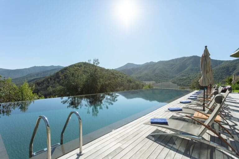 VIK Chile Hotel outdoor infinity pool, with a view of the forest and mountains.