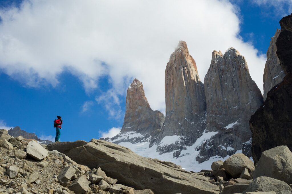 Hiker looking up at the Three Towers on Tierra Patagonia excursion.